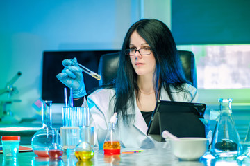 Chemical laboratory. The expert determines the solution ph in the tube using litmus strips....