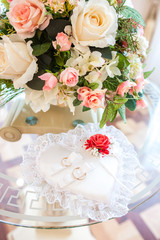 Wedding rings lie on a beautiful heart-shaped pillow. Wedding decorations.