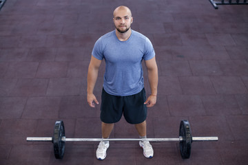 Fototapeta na wymiar Top view of a athletic man works out at the gym with a barbell