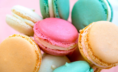 Colorful pastel cake macaron or macaroon on pink background