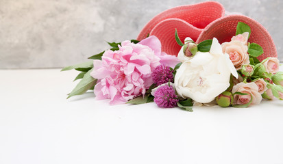 Summer background - flowers of peonies, roses, clover in a pink hat