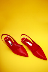 Red woman shoes isolated on the yellow background.