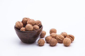 Walnuts in wooden bowl isolated on white background