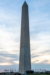 The Washington Monument at sunset, framed by trees and leaves