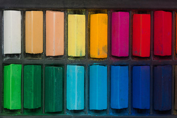 Chalk pastel stick in black container