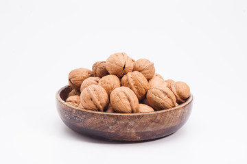 Wooden plate with walnuts isolated on white