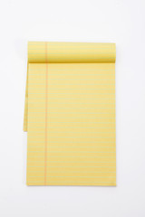 Yellow pencil on lined note paper isolated