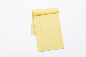 Yellow pencil on lined note paper isolated