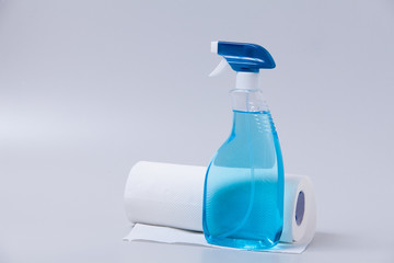 Window cleaner in plastic bottle with spray and fabric towel on gray (