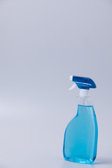 Window cleaner in plastic bottle with spray and fabric towel on gray (