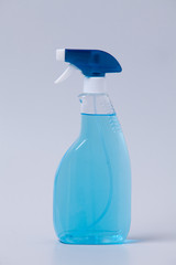 Window cleaner in plastic bottle with spray and fabric towel on gray (