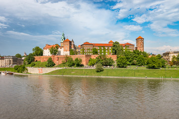 Wawel Castle and Wawel cathedral in the sun over the Vistula river on cloudy afternoon