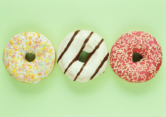 Delicious donuts on light pastel color background.