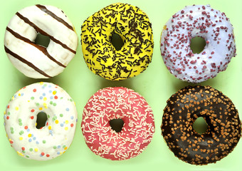 Delicious donuts on light pastel color background.