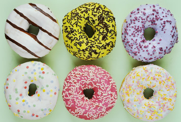 Delicious donuts on light pastel color background.