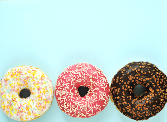 Delicious donuts on light pastel color background.