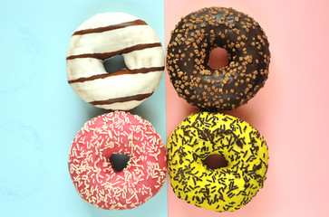 Delicious donuts on light pastel color background.
