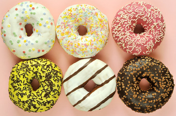 Delicious donuts on light pastel color background.