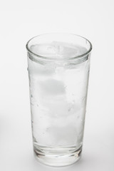 Glass of ice water with green leaf for fresh on white 