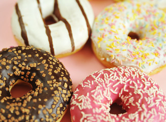 Delicious donuts on light pastel color background.