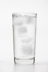 Glass of ice water with green leaf for fresh on white 