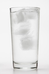 Glass of ice water with green leaf for fresh on white 