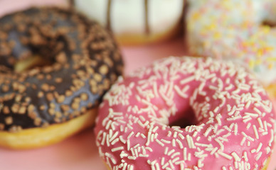 Delicious donuts on light pastel color background.