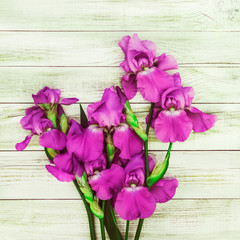 Iris flowers on light wooden background