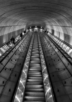 Commuters take a long escalator out of an underground subway station in Washington DC at night