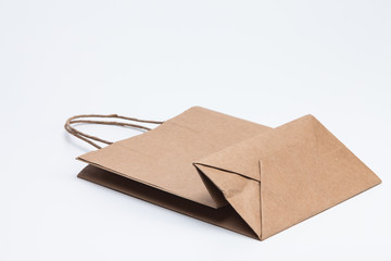 Brown kraft paper shopping bag lying on white 