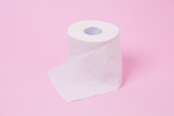 The roll of white toilet tissue paper on pink background