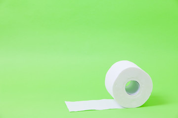 The roll of white toilet eco tissue paper on green background 
