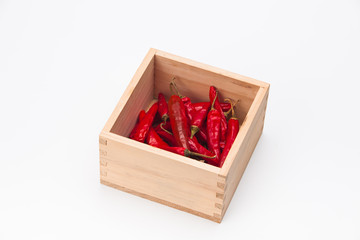 Red chilli peppers in wood bowl on white background