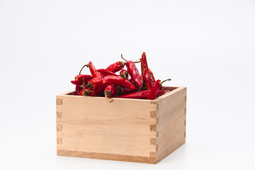 Red chilli peppers in wood bowl on white background