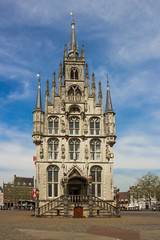 Gouda, Holland, Netherlands, April 23, 2019 - Mediaval gothic city hall in the center of old town square of Gauda, some close views of building with towers or lions holding emblems