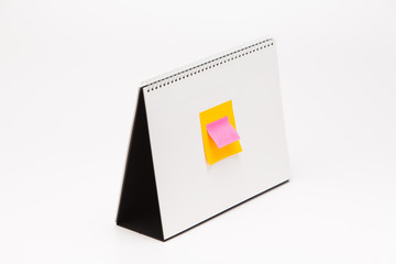  Color sticker with A white paper calendar stands on the table in photo