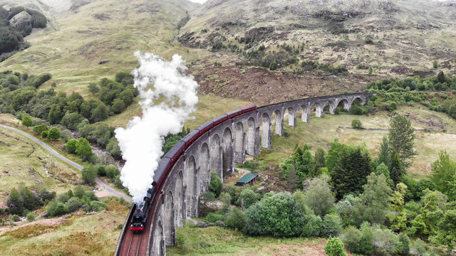 Steam Train crossing the Glenfinnan Viaduct, aerial view by drone - Scotland, UK © Rosana