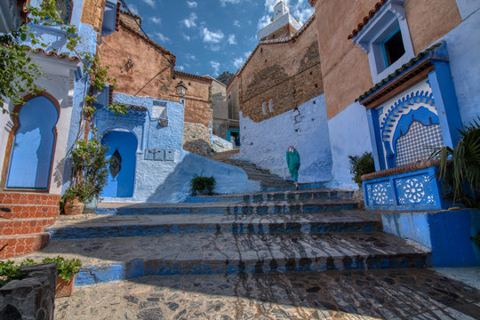 Chefchaouen, Morocco - May 3, 2019: Woman with Moroccan attire in a traditional streets of Chaouen, a very tourist city of northern Morocco