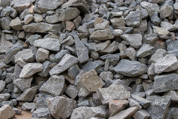 Gray stones cobblestone rough form, gravel building material, garden decor. Background texture close-up gray stones