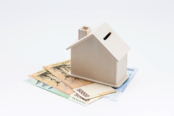 Wooden house coin bank on korean banknotes