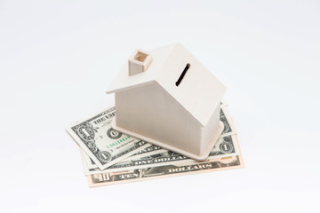 Wooden house coin bank on dollar finance