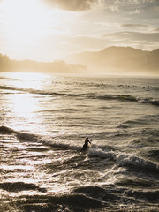Surfer girl getting in the water in San Sebastian