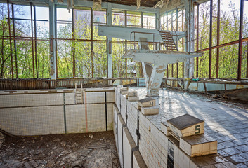Abandoned swimming pool in Pripyat. Destroyed gym in a radioactive city. The street is overgrown with trees and bushes.