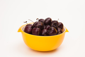 Fresh red cherries on yellow bowl