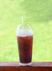Black coffee with ice on wood