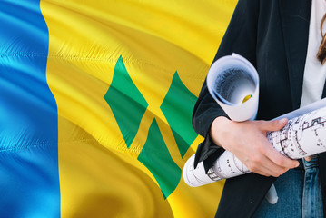 Architect woman holding blueprint against Saint Vincent And The Grenadines waving flag background....