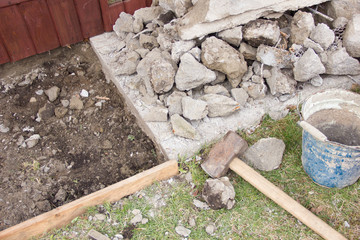 a huge sledgehammer breaks cement into stones
