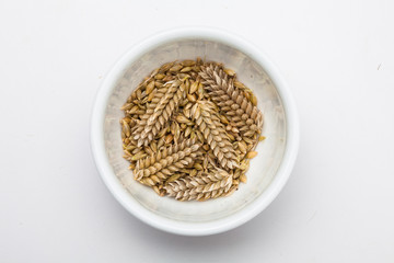 Ears of wheat and wheat grains in a bowl
