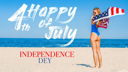 Beautiful cheerful woman holding an American flag on the beach.