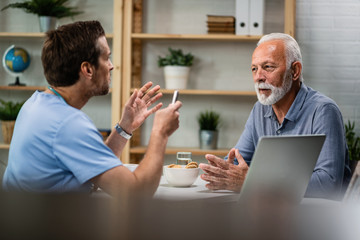 Senior man talking with a doctor during medical appointment.